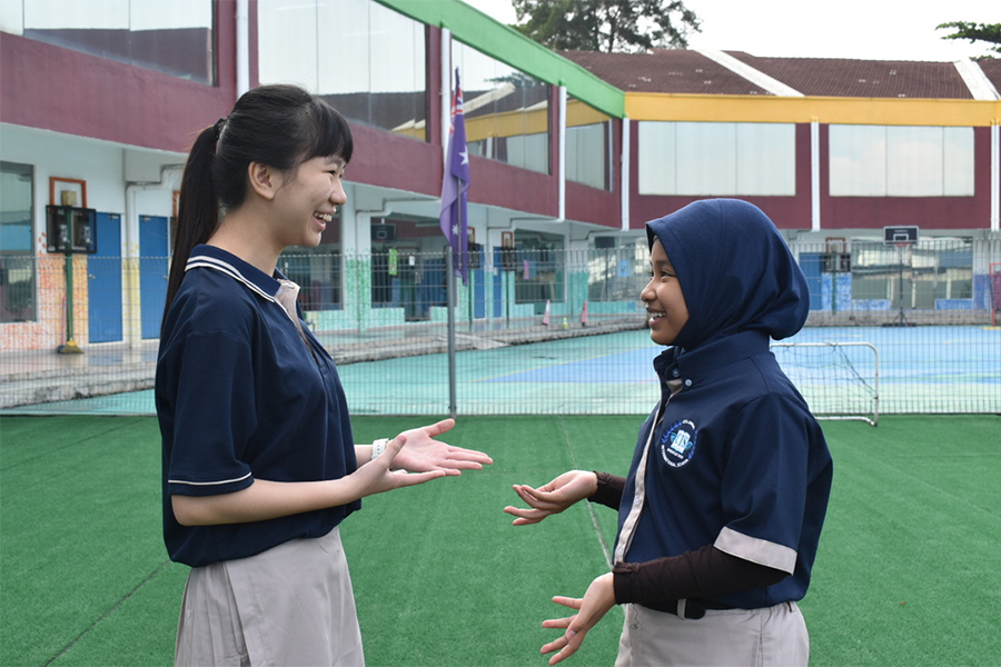Two girls are talking about the holistic education in Malaysia.